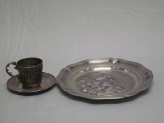 An Art Nouveau style silver plated coffee can and saucer and a circular pewter dish decorated shooting scene