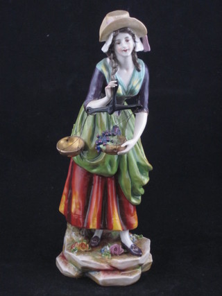 A 19th Century Continental porcelain figure of a standing lady  with pair of scales 10"