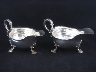A handsome pair of George IV silver sauce boats with scroll handles, raised on hoof supports, London 1827 and 1828, 1 with  slight tear, 14 ozs  ILLUSTRATED