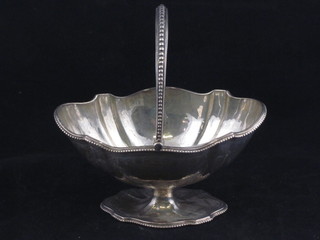 A Victorian embossed silver boat shaped sugar bowl with swing  handle raised on spreading foot, London 1853, 7ozs   ILLUSTRATED