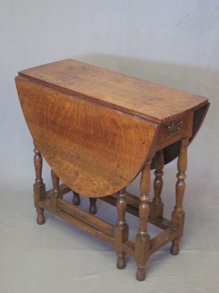 An 18th Century style oak dropflap gateleg tea table fitted a  frieze drawer and raised on turned supports 30"