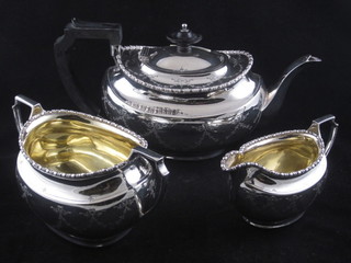 An oval engraved silver 3 piece tea service comprising teapot,  twin handled sugar bowl and cream jug, Sheffield 1922, 1923  and 1927 by Harry Atkin, 34 ozs