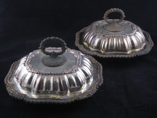 A pair of shaped silver plated entree dishes and covers