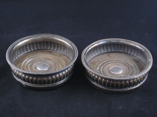 A pair of circular silver plated bottle coasters with demi-reeded  decoration
