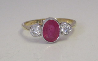An 18ct yellow gold dress ring set an oval cut ruby supported by  2 diamonds