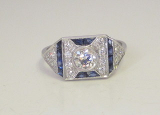 An 18ct white gold dress ring set sapphires and diamonds, the  centre set a diamond surrounded by square cut sapphires, approx  0.80ct