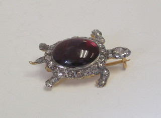 A gold brooch in the form of a tortoise set a cabouchon cut  garnet and diamonds