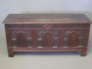 An 18th Century oak and elm coffer with hinged lid and arcaded decoration to the front, the interior fitted a candle box, 58"