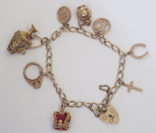 A gold curb link charm bracelet hung 9 various charms