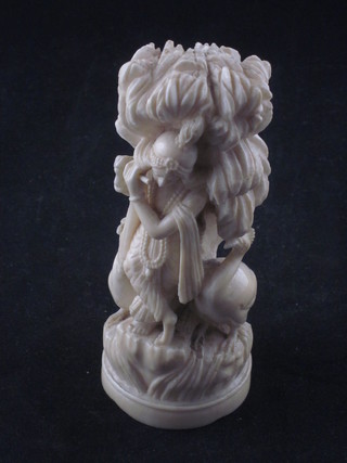 A carved Eastern ivory figure of a standing lady with flute