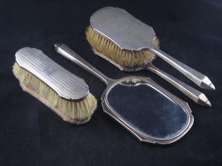 A silver backed 5 piece dressing table set comprising handmirror, pair of clothes brushes, pair of hair brushes