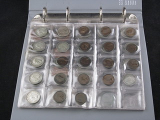 A black plastic ring binder album containing a collection of  coins, some silver