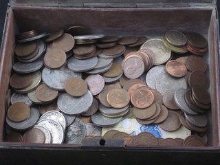 A metal box with hinged lid containing coins