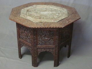 An Eastern octagonal carved and pierced hardwood table the top fitted a pierced copper tray decorated owl, 24"