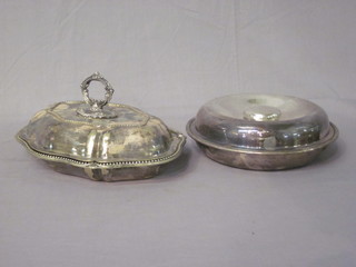 An oval shaped silver plated entree dish and cover and a circular ditto