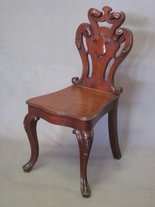 A Victorian mahogany hall chair the seat of serpentine outline  with shield shaped back