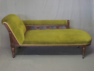 An Edwardian oak show frame chaise longue upholstered in  green material and raised on turned supports 71"