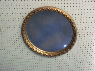 An oval convex circular plate wall mirror contained in a decorative gilt frame 16"
