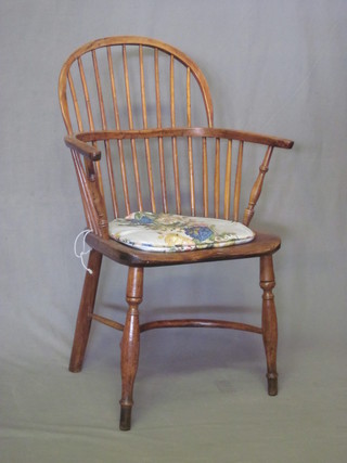 An 18th Century elm and yew Windsor stick back chair by Amos  of Grantham, with cown horn stretcher, missing back right hand  leg