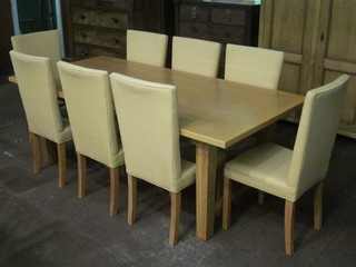 A rectangular oak extending dining table 83" together with 8 high backed chairs