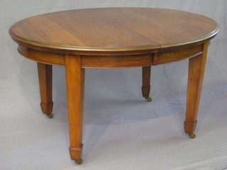 An Edwardian walnut oval extending dining table with 2 extra  leaves, raised on square tapering supports