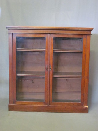 A Victorian walnut bookcase fitted adjustable shelves enclosed by  a glazed panelled door, raised on a platform base 42"