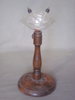 An 8 sheet blown glass novelty discharge tub, raised on a turned beech stand