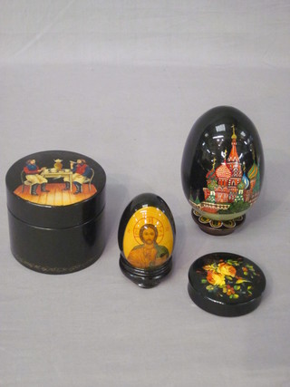 A cylindrical Russian lacquered trinket box the lid decorated a tea drinking scene, 2 ditto eggs and a cylindrical jar and cover