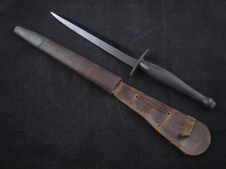 A Fairburn Sykes style fighting dagger with 6 1/2" blade  contained in a leather scabbard