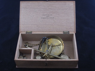A pair of brass pan scales and a collection of weights contained  in a box marked HM Stanley