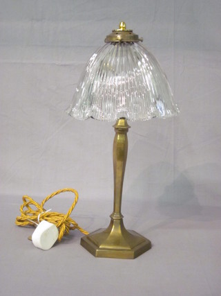 A brass table lamp with clear glass shade