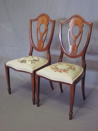 A pair of Edwardian inlaid mahogany Hepplewhite style shield back chairs with upholstered seats, raised on square tapering  supports ending in spade feet