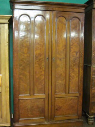 A Victorian mahogany wardrobe with moulded cornice, the  interior fitted trays and drawers enclosed by panelled doors,  raised on a platform base 50"