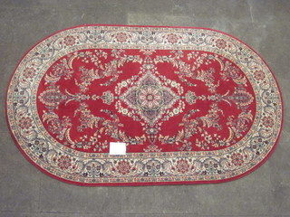 An oval red ground Persian style rug 76" x 48"