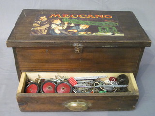 A wooden box containing various items of Meccano