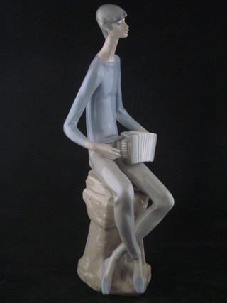 A Nao figure of a seated accordionist, leg f and r, 12"