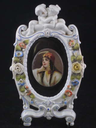 A Continental porcelain head and shoulders portrait miniature of  a lady, contained in a floral encrusted porcelain frame, f and r,  8"