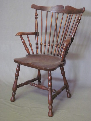 An elm 19th Century stick and rail back "Goldsmiths" Windsor carver chair raised on turned supports with H framed stretcher