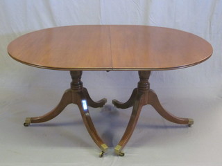 A Georgian style mahogany D end extending dining table, raised  on twin pillar tripod supports with 1 extra leaf