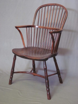 An 18th/19th Century yew and elm stick and rail back carver  chair with solid elm seat and cown horn crinoline stretcher, some  old worm to the base,