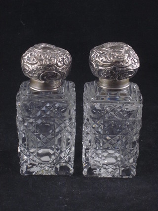 A pair of Edwardian square cut glass scent bottles with embossed silver lids, Birmingham 1903 4 1/2"