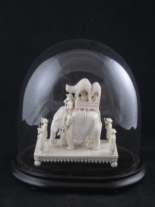 A carved ivory figure of an elephant with attendants contained under a glass dome 5"