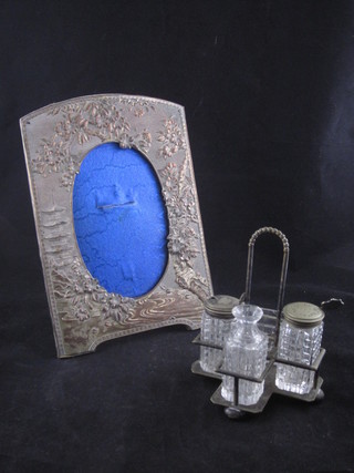 An embossed easel photograph frame and a glass and silver  plated cruet