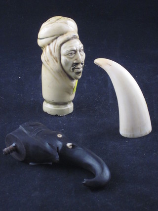 A small section of carved ivory tusk 2", a walking stick head in the form of a nomad 4" and an ebony walking cane handle in the  form of an elephant 4"