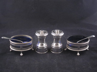 A pair of oval pierced silver plated salts with blue glass liners  and 2 silver plated pepper mills