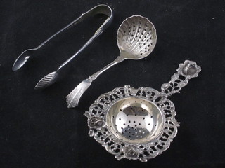 A silver tea strainer, a silver sifter spoon and a pair of silver  sugar tongs, 2 ozs