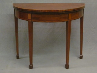 A Georgian mahogany demi-lune card table with inlaid mahogany crossbanded top, raised on square tapering supports ending in  spade feet 35"  ILLUSTRATED