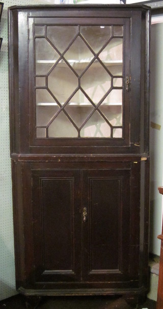 A 19th Century double corner cabinet, the upper section with moulded cornice, the shelved interior enclosed by an astragal  glazed panelled door, the base fitted a double cupboard, raised on  bracket feet 36"