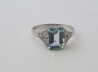 A lady's 18ct white gold dress ring set a rectangular cut aquamarine supported by diamonds