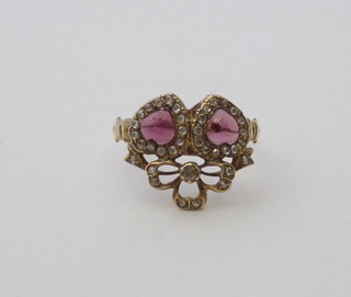 A lady's gold dress ring in the form of 2 entwined hearts  set cabouchon garnets supported by diamonds